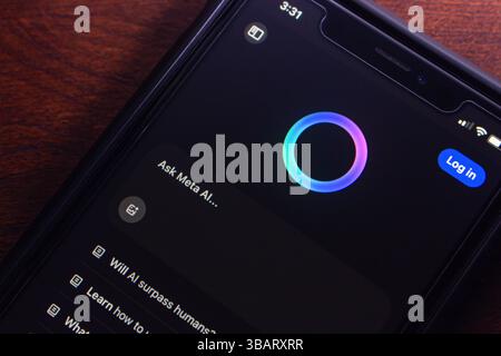 A smartphone displaying Meta AI's chat interface, showing a login button and futuristic circular assistant animation. Stock Photo