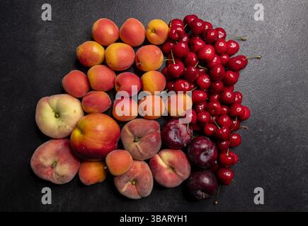 Peach, apricot, cherry and plum forming a colorful gradient on a dark background Stock Photo