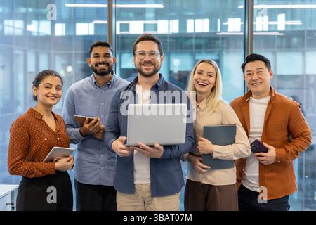 A diverse team of colleagues smiles with joy and confidence while looking at the camera in the office. Collaboration. Stock Photo