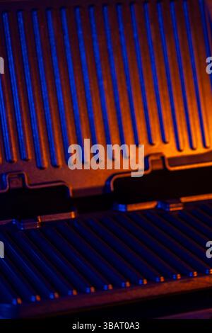 Empty electric grill radiating a vibrant orange and blue light, creating a modern and futuristic atmosphere Stock Photo