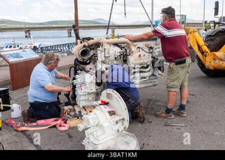 New Boat engine being installed on tourist boat by crane, Portmagee, County Kerry, Ireland Stock Photo