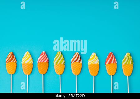 Vibrant and playful summer layout made of ice cream shaped lollipops on light blue background. Creative candy concept. Colorful sweet food background. Stock Photo