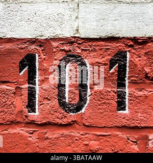 House number 101 painted black with white shading on red brickwork - Brussels, Belgium. Stock Photo