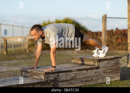 Young man in push up position at outdoor gym Stock Photo