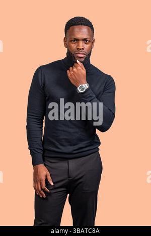 Studio portrait of a thoughtful businessman touching his chin while wearing a turtleneck sweater and a wristwatch Stock Photo