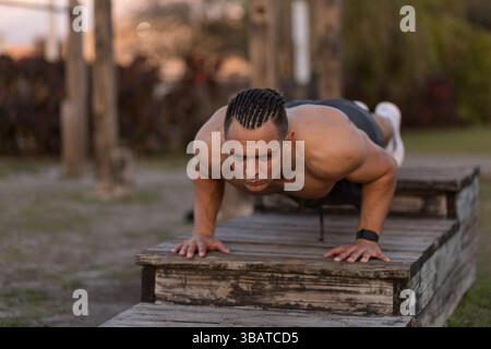 Young man in push up position at outdoor gym Stock Photo