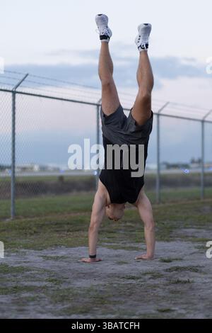 Handstand Outside Man doing a handstand push-up using floor bars balancing on his hands ...