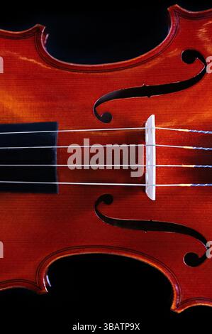 A close up of the waist, bridge, and strings of a violin Stock Photo
