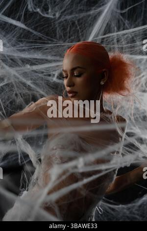 Red-haired woman caught in an elaborate net trap with ethereal beauty Stock Photo