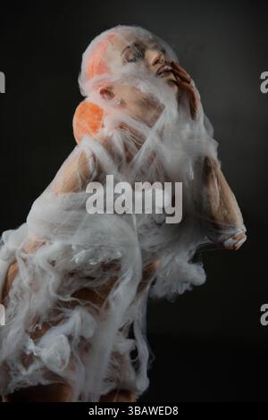 Captivating red-haired woman ensnared in delicate net trap Stock Photo