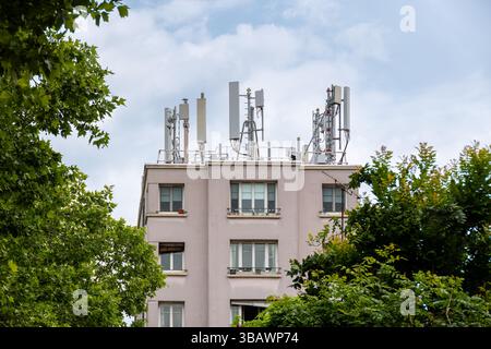 4G and 5G antennas belonging to a telecommunications operator on the roof of a residential building. Concept of mobile phone network coverage Stock Photo