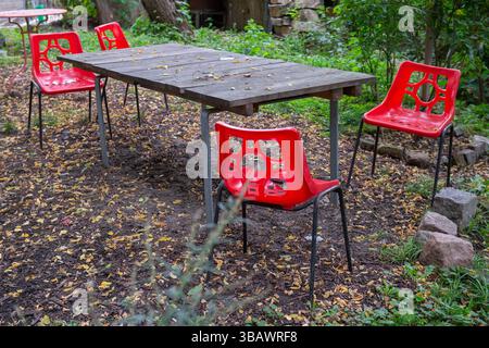 17.10.2023, Germany, Berlin, Berlin - Table in the garden with four red plastic chairs. 0CE231017D001CAROEX.JPG [MODEL RELEASE: NO, PROPERTY RELEASE: Stock Photo
