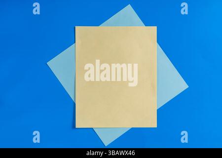 Yellow and blue sheets are creatively arranged on a bright blue background, creating a simple yet captivating composition suitable for design or conce Stock Photo