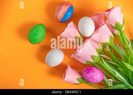 A vibrant decorative scene with pink tulips and hand painted Easter eggs evokes seasonal celebration. Stock Photo
