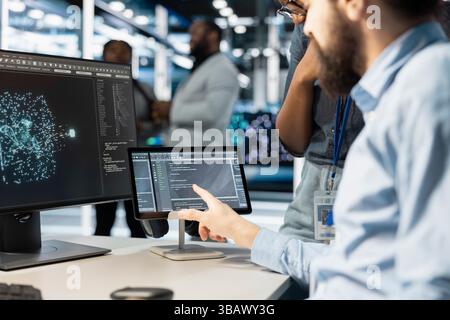 Close up of computer scientists in data center office integrating AI driven automation tools. Server farm employees cooperating, using artificial intelligence deep learning models Stock Photo