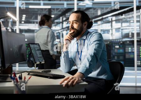 System administrator using computer in data center, managing server virtualization, running scripts. IT specialist using programming language on PC in server farm, finetuning network protocols Stock Photo