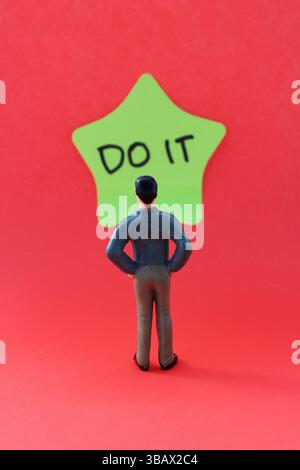 Businessman in front of a star-shaped sticky note that says DO IT Stock Photo