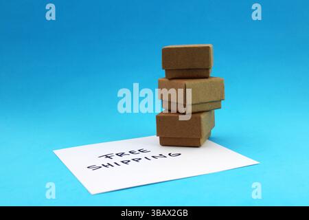 Free shipping phrase next to three cardboard boxes, package delivery Stock Photo