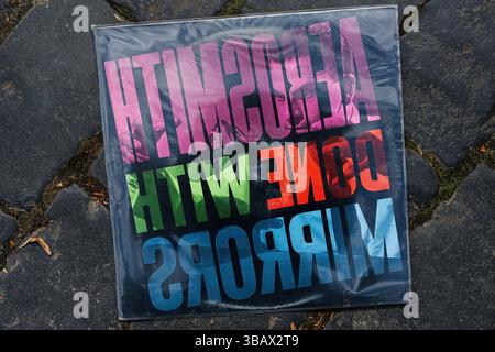 Lviv, Ukraine - May 13, 2025: Colorful 1985 album artwork of Aerosmith Done with Mirrors displayed on stone tiles Stock Photo