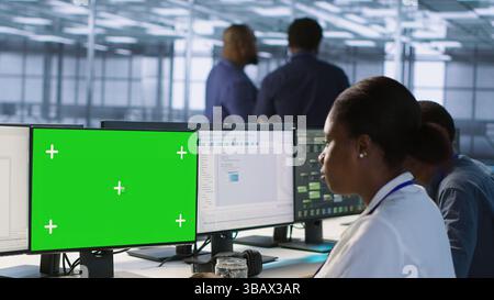 Software developer in server farm ensuring data remains shielded from potential threats using mockup PC. IT expert safeguarding data center against hackers with green screen computer, camera A Stock Photo
