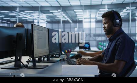 Engineer in server room looking over documents, developing disaster recovery plans ensuring minimal downtime. Worker reading paperwork in data center, using analytics to monitor performance, camera A Stock Photo