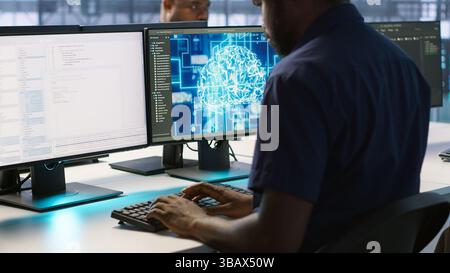 African american worker in data center implements advanced AI driven predictive maintenance systems. Engineer using artificial intelligence to identify hardware failures impacting operations, camera A Stock Photo