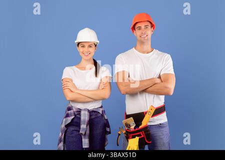 Confident young couple in hard hats ready for house repairment and renovation Stock Photo