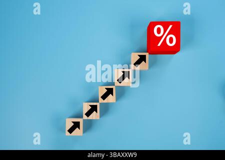 Red wooden blocks arranged as a bar graph with upward arrows and percentage symbols, symbolizing increasing interest rates. Business growth success pr Stock Photo