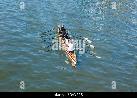 Academic rowing, four athletes with a coxswain sail in a boat on open ...