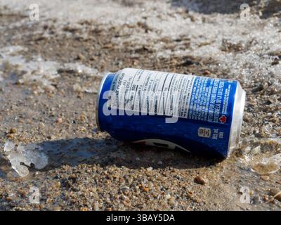 Empty cola can laying on the side of the road in the Spring,Quebec,Canada Stock Photo