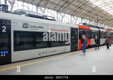 Passengers with luggage walk and wait on a covered platform between regional and long-distance trains at Prague Central Station. Prague, Czech Republi Stock Photo