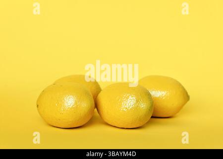 Four lemon fruits on yellow background with copy space Stock Photo