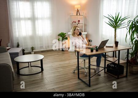 Engaging in a productive remote work session in a modern and bright home office space Stock Photo