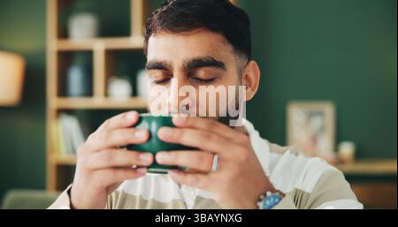 Home, sofa and man with coffee for smell, warm beverage and espresso in living room on weekend. House, male person and relax with aroma for matcha Stock Photo