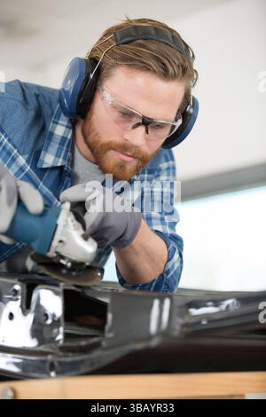male mechanic using angle grinder Stock Photo