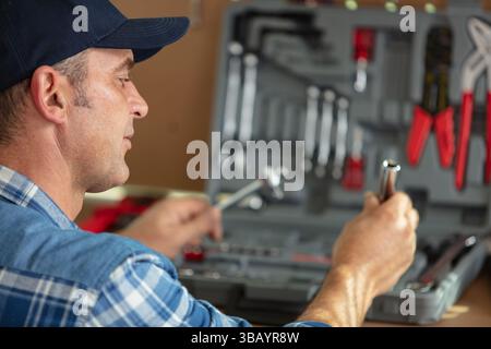 handyman searching tools in toolbox Stock Photo