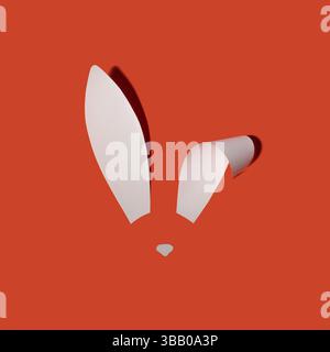 Rabbit ears from white paper on orange background. Easter minimal concept. Flat lay. Stock Photo