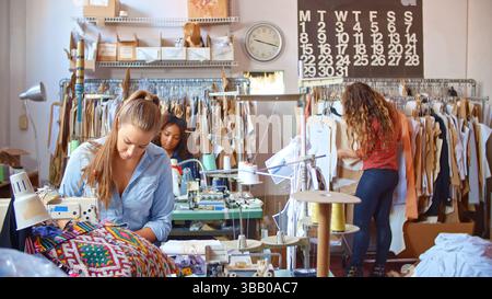 Female Staff Working At Sewing Machines In Clothing Factory Stock Photo
