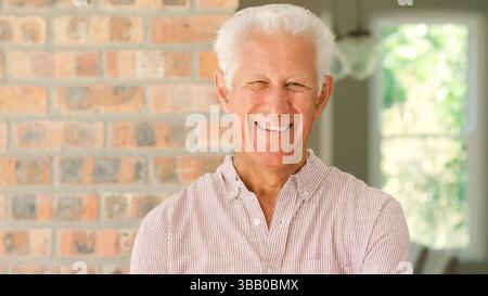 Head And Shoulders Portrait Of Smiling Senior Man At Home Stock Photo