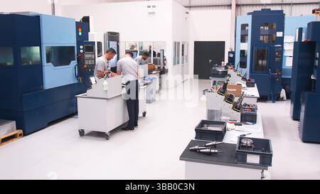 Busy Engineering Workshop With Workers Using CNC Machinery Stock Photo