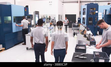 Busy Engineering Workshop With Workers Using CNC Machinery Stock Photo