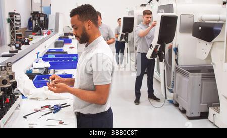 Male Engineer Measuring Components In Hi Tech Engineering Plant Stock Photo
