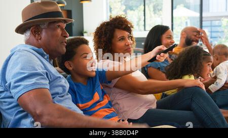 Multi-Generation Male African American Family Sitting On Sofa At Home Using Digital Tablet Stock Photo
