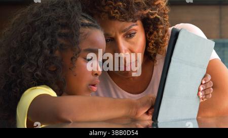 Close Up Of Grandmother With Granddaughter Indoors At Home Using Digital Tablet Stock Photo