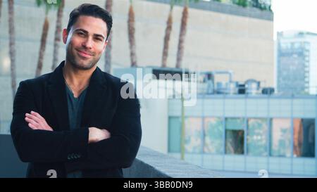 Portrait Of Smiling Mature Businessman Outside Office Building With City Skyline In Background Stock Photo