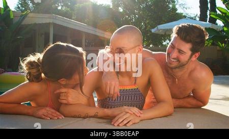 Group Of Friends Outdoors Relaxing In Swimming Pool And Enjoying Summer Pool Party Stock Photo