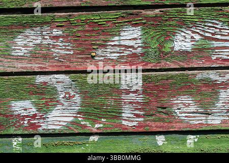 A background with the texture of wooden planks with peeling green paint and white numbers. Close-up, a wooden railway car from the Second World War wi Stock Photo