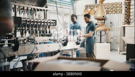 Manufacturing, people and bottling on conveyor belt in distillery for alcohol production, packaging or distribution. Assembly line, team and quality Stock Photo