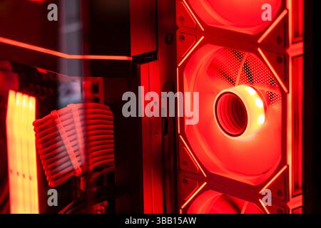 Red illuminated cooling fan actively dissipating heat in a custom-built personal computer, showcasing advanced technology and gaming aesthetics Stock Photo