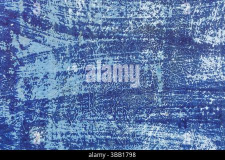 Chaotic blend of blue and white lines and blotches creates abstract pattern on weathered surface, cracking from years of exposure to harsh sunlight. Stock Photo